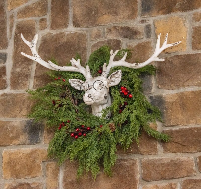 Fresh greens yoke a studious reindeer above the fireplace at Geri Ludlam and Connie Heindel’s Hudson Road home.